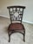 Vintage faux bamboo side chair featuring an elegant Chippendale-inspired fretwork back and woven rattan seat. Finished in...