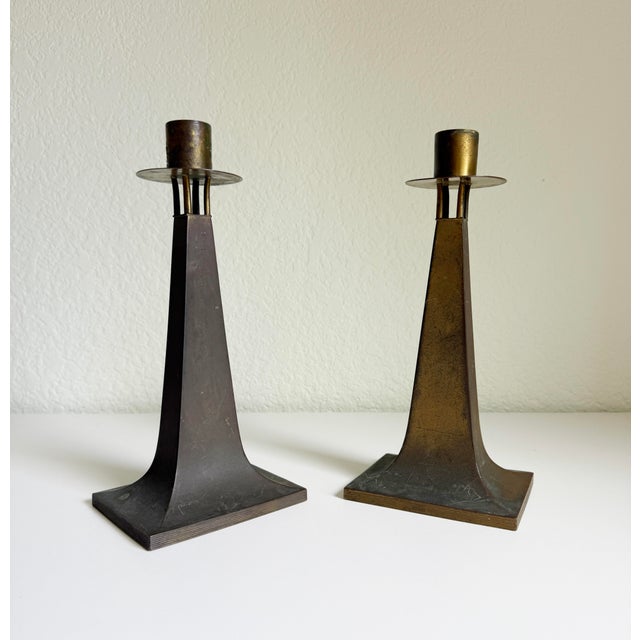 A pair of Arts & Crafts style candlesticks, circa late 1800s to early 1900s. Clean and modern form paired with a rustic,...