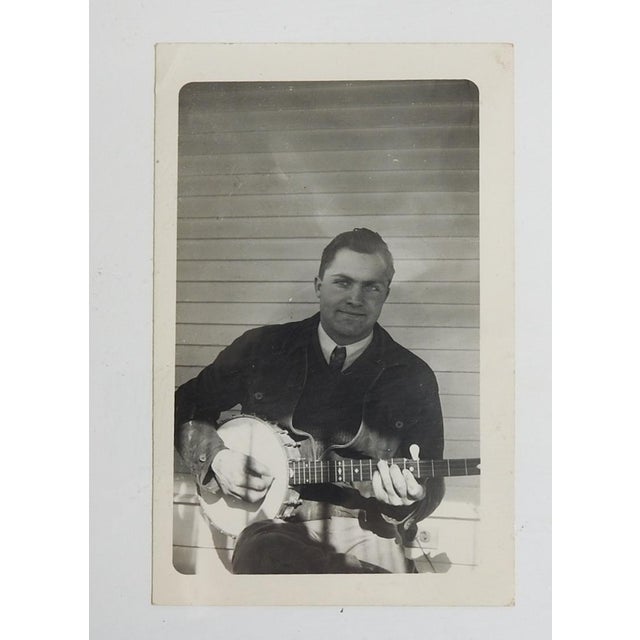 Mid 20th century snapshot photograph of man playing a banjo. Unframed, corner crease.