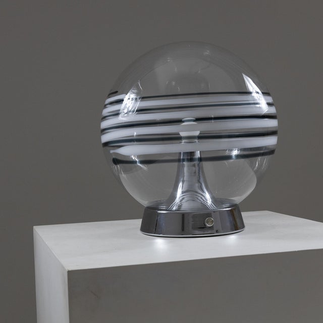 Large table lamp with chromed metal base and transparent glass diffuser with black and white decorative lines. European...