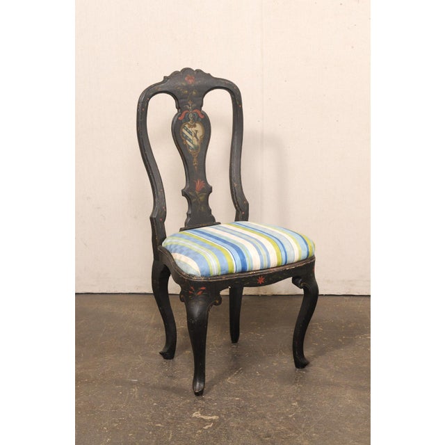 A French provincial pair of black painted side chairs, with hand-painted accents and upholstered seats, from the 19th...