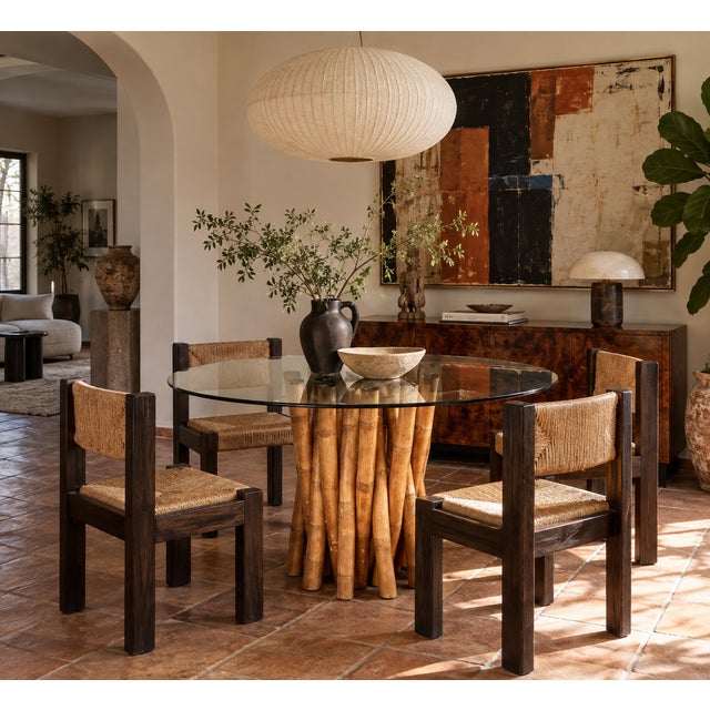 This vintage dining table lets the base do all the talking — dozens of natural bamboo poles, varying in diameter and cut...