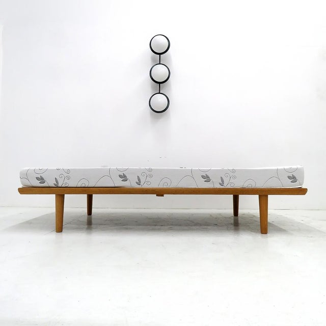 Wonderful daybed GE-19 by Hans J. Wegner for GETAMA, 1956, solid oak frame with tapered legs and brass end rail accents,...