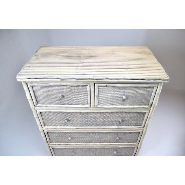 A solid Coastal wood faux bamboo five drawer dresser with split reed surround enhanced with grasscloth to the faces of the...
