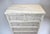 A solid Coastal wood faux bamboo five drawer dresser with split reed surround enhanced with grasscloth to the faces of the...