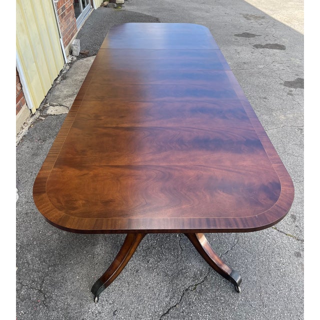 A commanding presence for the formal dining room, this double pedestal flame mahogany dining table is attributed to...