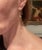 A pair of 14-karat yellow gold lightning bolt earrings with freshwater pearl accent at center. Excellent condition as...