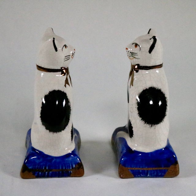 Fantastic set of Staffordshire style cats on cobalt blue pillows. These have a crackle finish and gold accents on the bows...