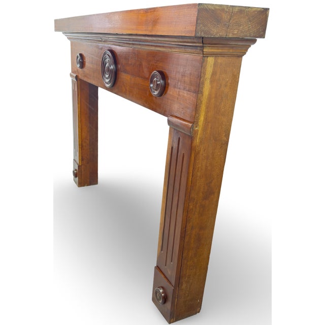 The fireplace mantelpiece features a beautifully crafted wooden design that serves as a striking element in any room. Made...