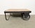 Former pallet truck from a factory now serves as a coffee table. It features a black iron construction with two original...