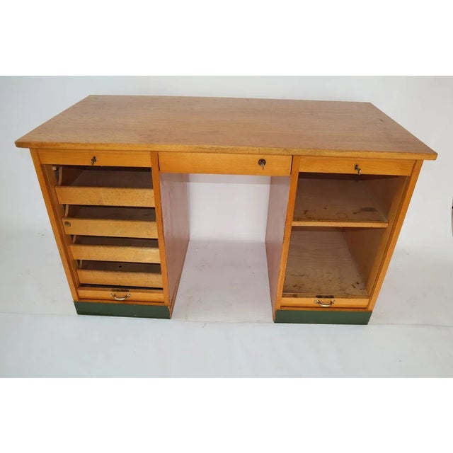 Wooden roller desk manufactured in the 1960s. The furniture has two lockable side drawers and one pull-out drawer. Two...