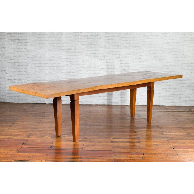 A vintage Indonesian large dining table from the mid 20th century, with mango wood top and tapered legs. Created in...