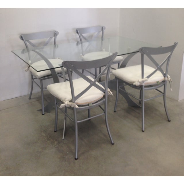 We love how this dining set blends an aerodynamic, futuristic base with more traditional, cross back chairs, and finishes...