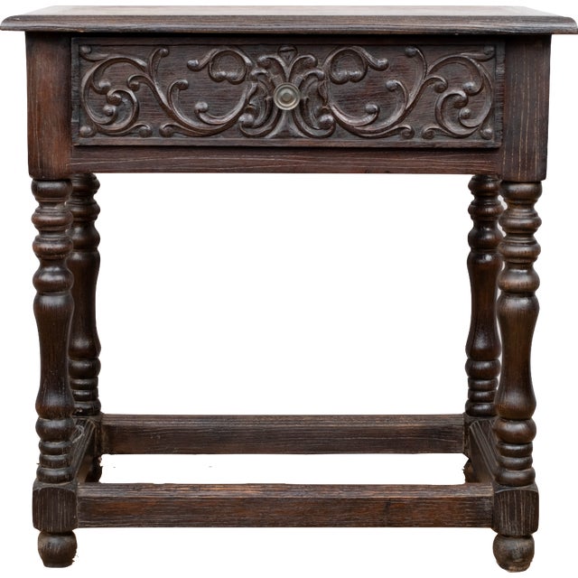 A dark stained side table, early 20th century, American. Made from oak in the Spanish Revival style. Featuring a single...