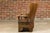 A rustic English walnut lambing chair from the 19th century with curving arms and carved base. Whisk your home's ambiance...