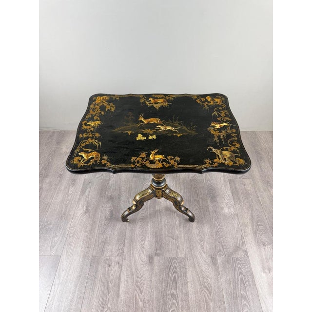An elegant 19th-century folding table in the Napoleon III style, crafted from black lacquered wood and richly decorated...