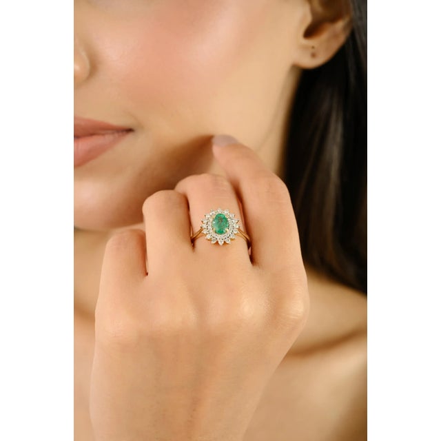 This Vintage 18k Yellow Gold Emerald & Halo Diamond Cluster engagement Ring, masterfully crafted in luxurious 18k yellow...