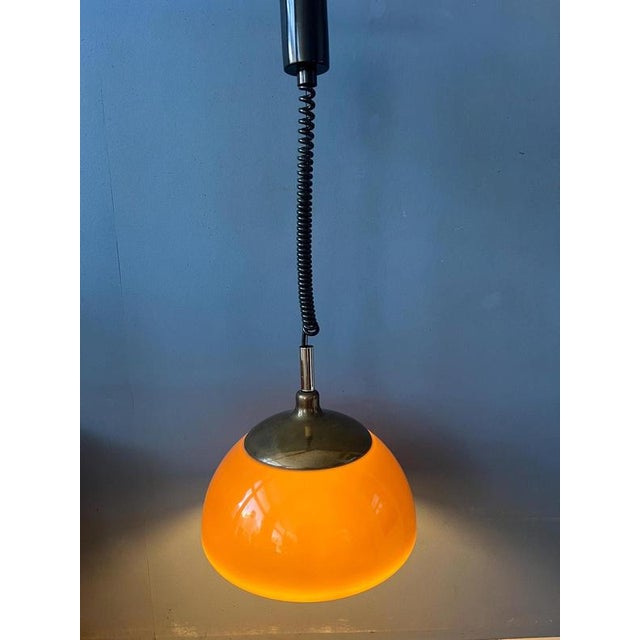 Astonishing space age pendant lamp by Cosack leuchten from thick acrylic glass and a metal top cap. The brown part of the...