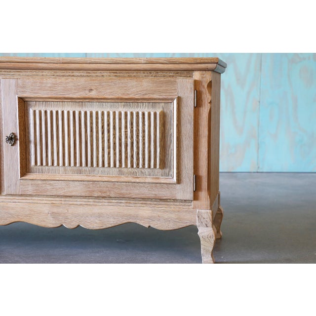 A smaller sideboard cabinet in the style of Henning Kjaernulf, made of oak veneer. The solid oak doors with a carved...