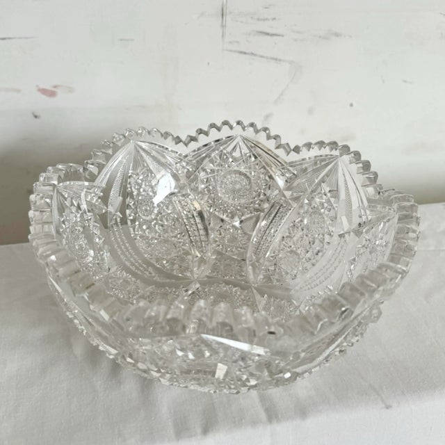 This stunning vintage cut crystal bowl showcases intricate geometric patterns and a striking sawtooth edge, reflecting...