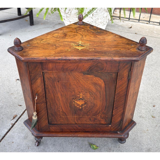 Antique Petite English Inlaid Walnut Corner Cabinet. This is an antique walnut corner cabinet featuring rich burl wood...