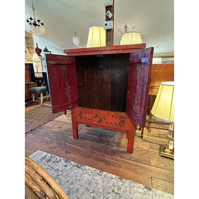 Large striking red and gold Chinoiserie cabinet having two doors that open to storage within. No shelf but there is a...