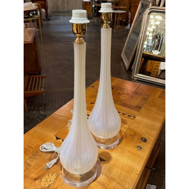 The product is a pair of Murano glass lamps that feature an opalescent glass and a vase form design, giving them a unique...