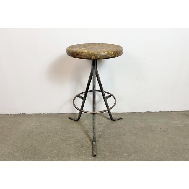 Vintage Industrial factory stool made in former Czechoslovakia during the 1960s It features a wooden seat and a grey iron...