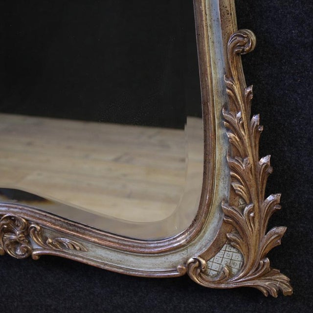Mid-20th-century French mirror. This Louis XV-style piece of furniture is in carved, lacquered, and silvered wood features...