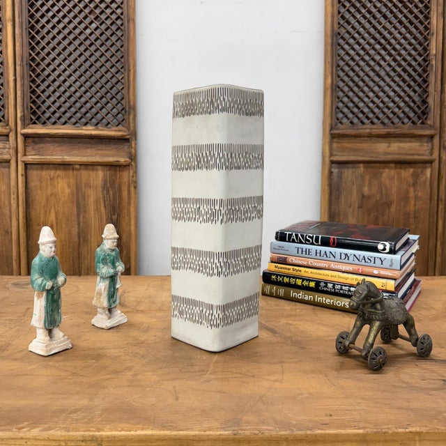 "About This Piece About This Piece Make a bold yet refined statement with this tall ceramic vase that plays with rhythm...