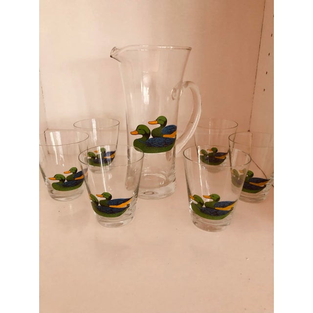 Gorgeous 1930s pitcher and glasses set. The set depicts colorful mallard ducks in bright blue, green and yellow. The...