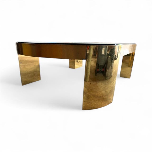 This is a large, substantial brass and glass racetrack coffee table, attributed to Karl Springer. It dates to the 1970s...