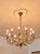 French empire chandelier made of polished brass, richly shaped with twelve arms ending in e14 bulb holders. The decorative...