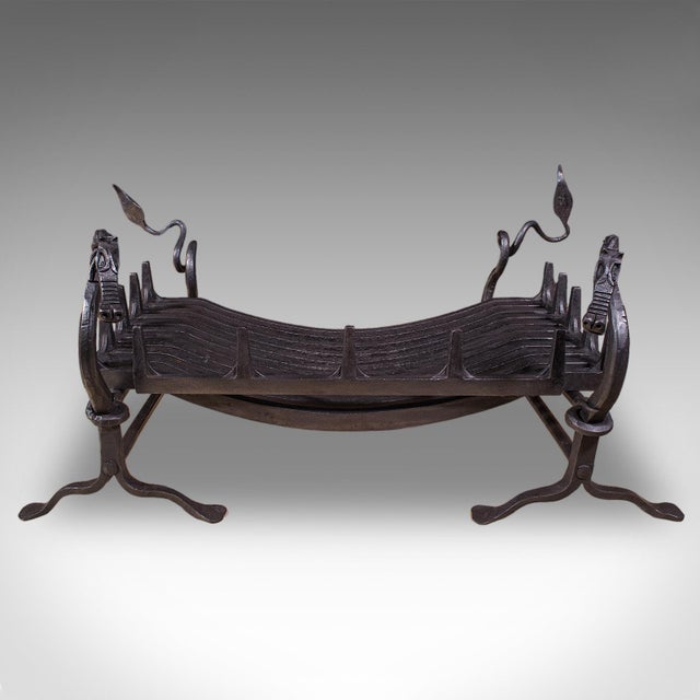 This is an antique Dragon motif fireplace set. An English, estate-made cast and wrought iron fire basket and andirons...