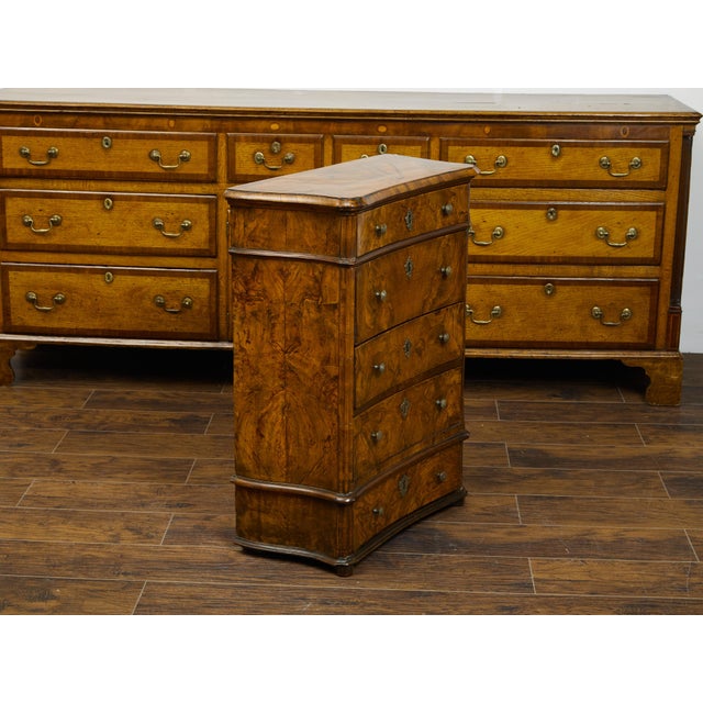 An Italian petite walnut commode from the early 19th century, with butterfly veneer and five drawers. Created in Italy...