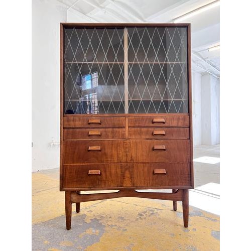 This Danish display cabinet is an exquisite example of 1950s craftsmanship and embodies early mid-century style at its...