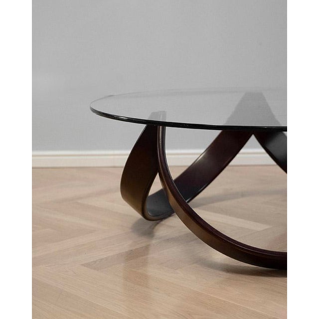 The coffee table dates back to the 1970s, designed and made in Italy. The table has a wooden structure with curved legs...
