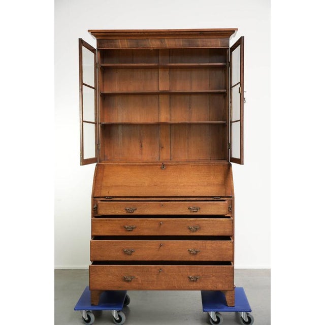 This antique English bookcase/secretary dates from the 18th century and is made of oak. The secretary consists of two...
