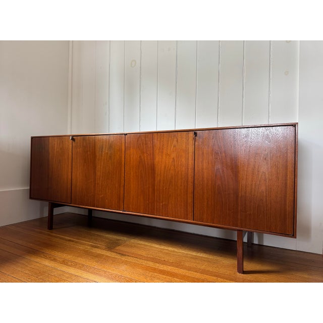 Mid century walnut credenza by Florence Knoll Two sets of barn door cabinets 4 doors); the right side is open, the left...
