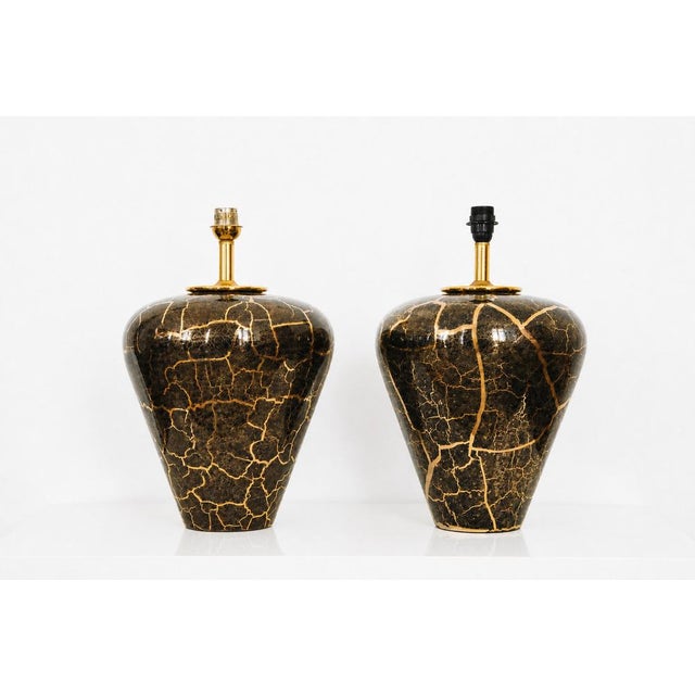 Elegant pair of 20th century table lamps crafted in glazed ceramic, featuring a striking crackle finish. The deep black...