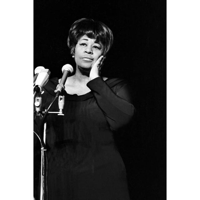 This poignant black-and-white photograph captures the iconic jazz singer ella fitzgerald in a moment of deep introspection...