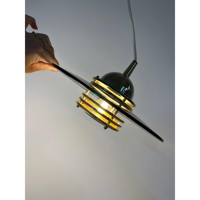 This pendant lamp, crafted from smoked glass and brass by Jan Eskil Eskilsson for the renowned Swedish manufacturer Belid,...