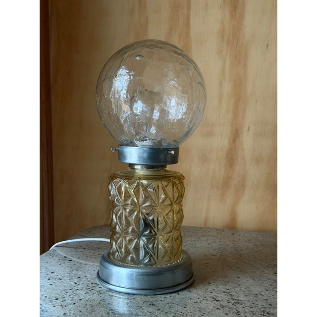 A beautifully atmospheric vintage lamp with sculptural presence and soft, glowing light. this piece pairs a delicate...
