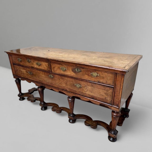 A fine early 19th century English William and Mary walnut low dresser or huntboard, with bookmatched and crossbanded top....