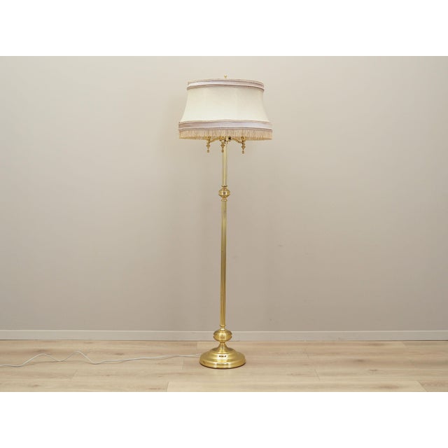 The lamp was made in the 1970s, Danish production. Made of metal in gold colour. Lampshade covered with fabric in beige....