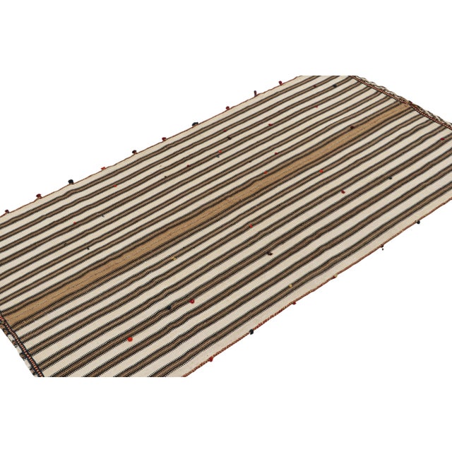 This vintage 5x9 Kilim is believed to be a tribal rug of the 1950s. Handwoven in wool, its design reflects a tribal panel...