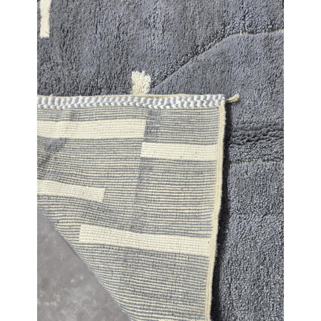 Gray Moroccan Rug – Handmade Abstract Berber Wool Rug This elegant handmade Moroccan rug features a soft gray wool field...