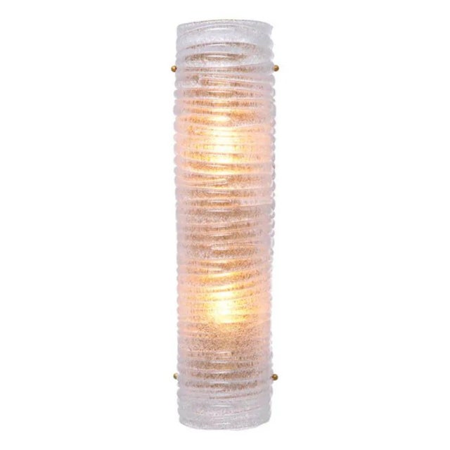 This contemporary antique brass wall lamp is a modern wall light made from antique brass-finished metal and hand-blown...