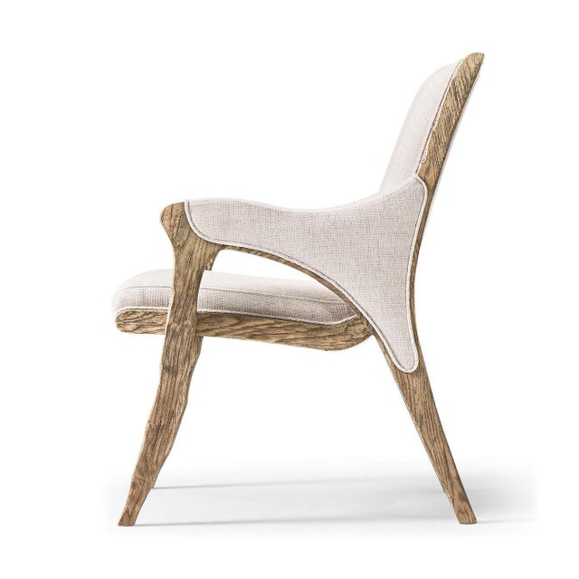 The armchair embodies a refined balance of traditional craftsmanship and contemporary restraint, pairing a sculpted solid...