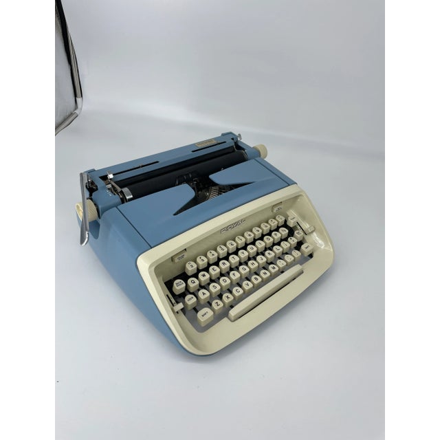 Vintage Mid Century Royal Aristocrat portable typewriter. Features a bright blue color body with creamy white keys and...